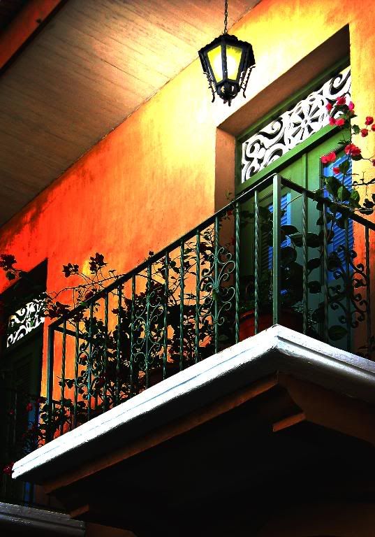outdoor ideas decoration ideas Terrace and balcony decoration: choosing the right colors! Romantic-balcony-with-carved-door-,-red-roses-along-the-grille-and-lamp-with-iron-covering