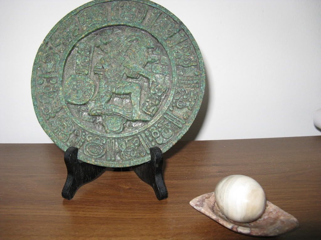 Photograph of the Mayan calendar and the jade egg resting on its tray.