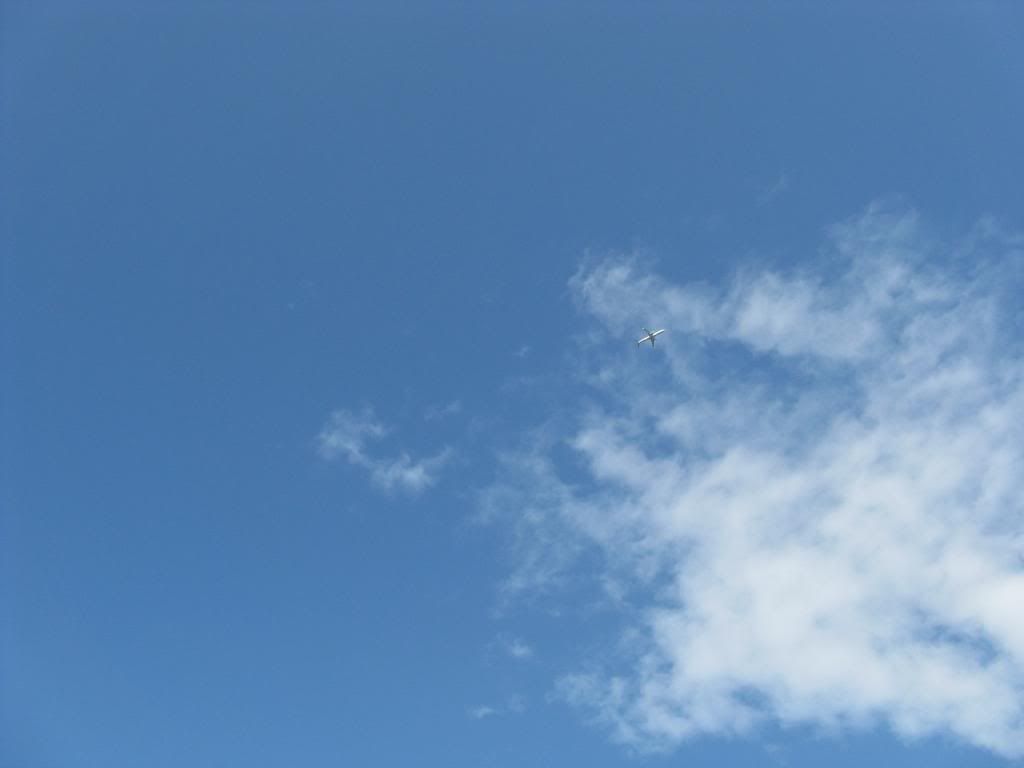 A small plane crosses a huge blue sphere up above.