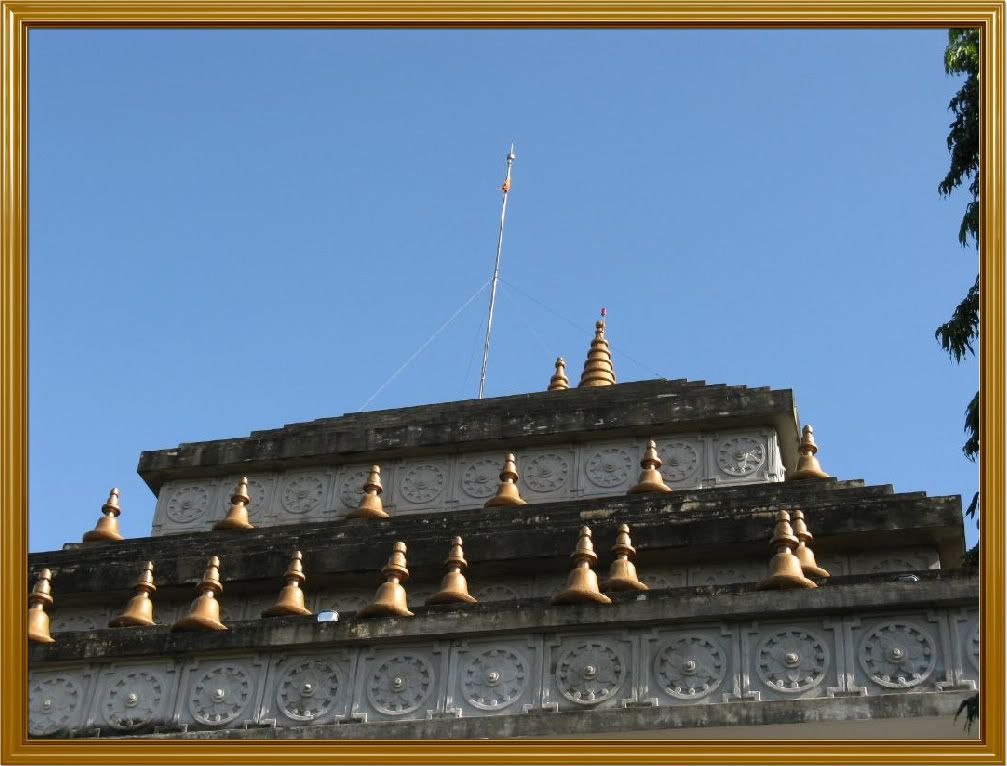 A close up view of the roof of the temple. Notice the bell-shaped figures and the clean blue sky. Not a single white cloud in sight.