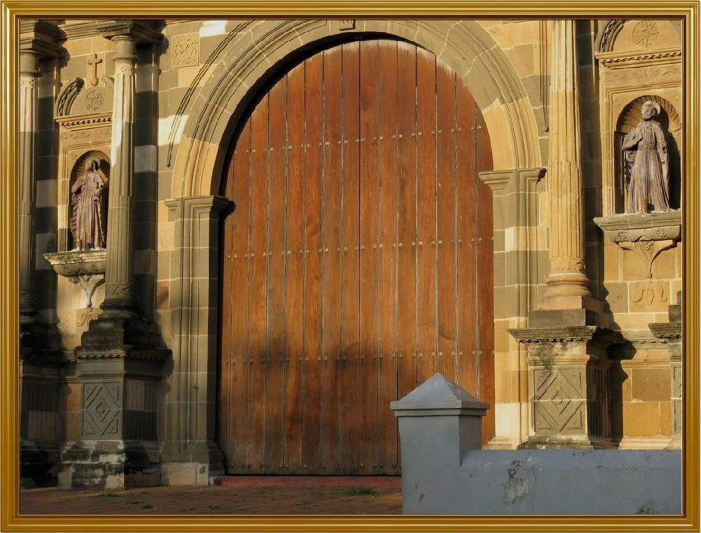 Photograph of the solid wooden door at the entrance of the cathedral. The size of the door is impressive.