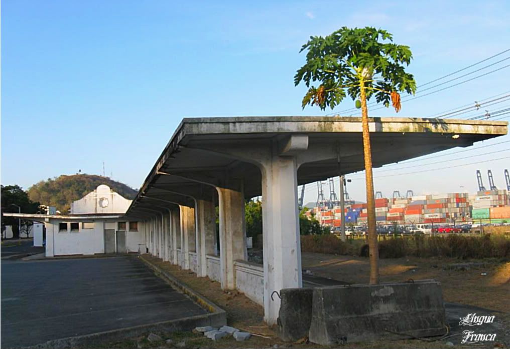 Photograph of the platform where the passengers boarded the train. This section of the building is in ruins. In the distance you can see the port of Balboa moving a large quantity of containers. (Credit: Omar Upegui R.)