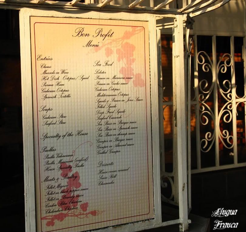 Photograph of an English menu on the outside of the Bon Profit Restaurant. As you can see, the specialty of the house is Paellas, Meats & Poultry and Sea Food. (Credit: Omar Upegui R.)