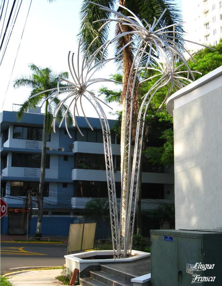 Picture of three metallic palm trees which blends nicely with two natural palm trees behind them. I found these elegant metallic palm trees at Via Argentina in Panama City, Panama. (Credit: Omar Upegui R.)