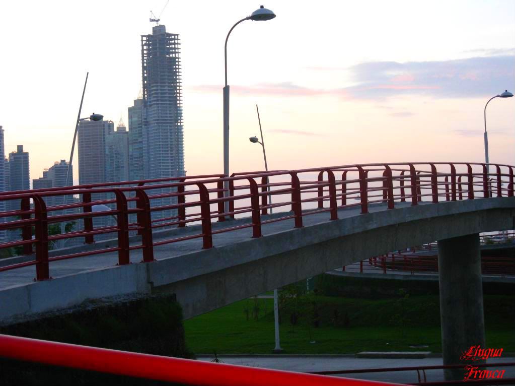 Photograph of a red pedestrian bridge at la Cinta Costera in Panama City, Panama. You can see a new building unders construction in the background. (Credit: Omar Upegui R.)