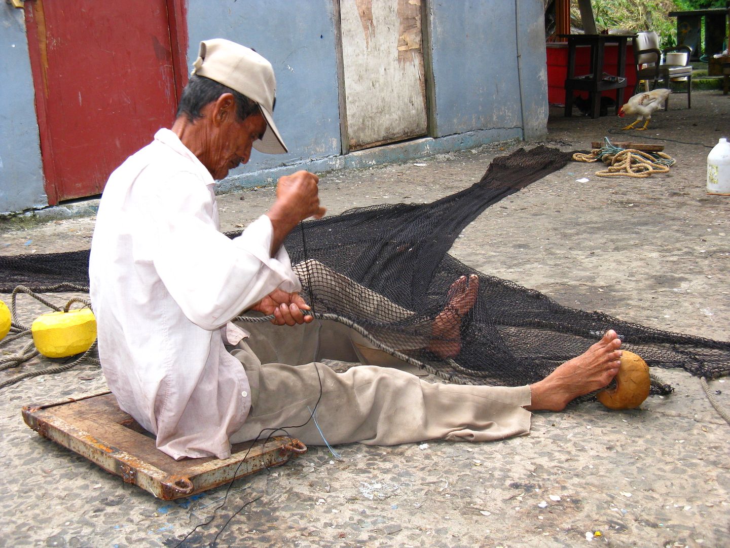 Photograph of Jaime, the fisherman, concentrated on his work sitting on top of a hard surface. (Credit: Omar Upegui R.)