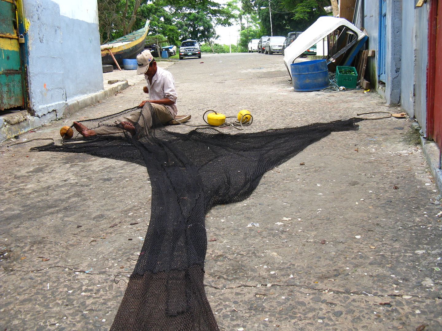 Photograph of an elder fisherman fixing his net at a small cooperative at the entrance of the Panama Canal. (Credit: Omar Upegui R.)