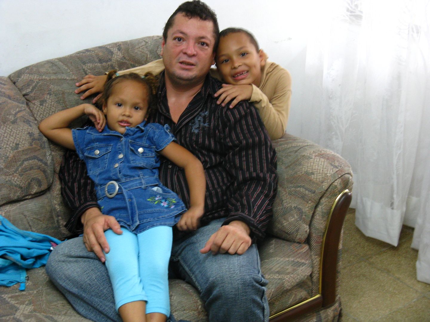 Photograph of Alcibiades and his two children, Abdiel and Karol. Karol poses for the camera with a unique style. Nobody told her to pose like this; it was a spontaneous action. (Credit: Omar Upegui R.)