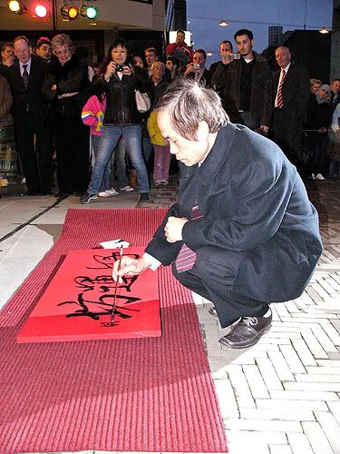 Chinese kalligraaf schildert tekens op een rood doek