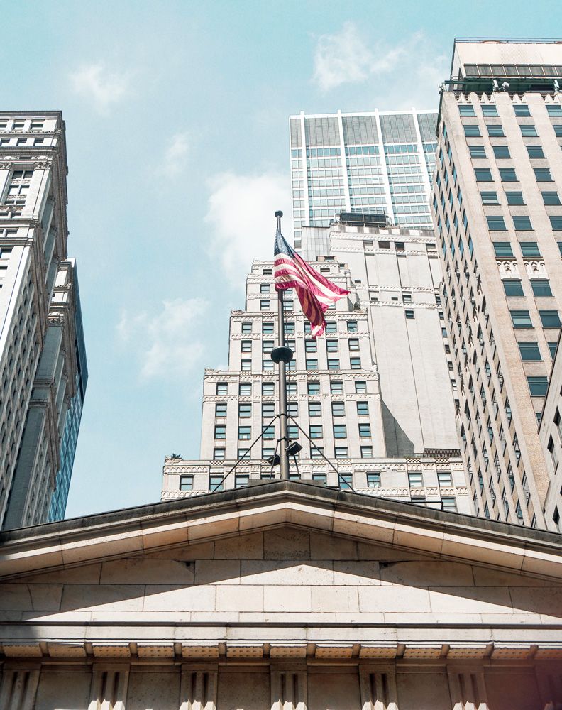 wall street with flag and sky by Maely Schassin